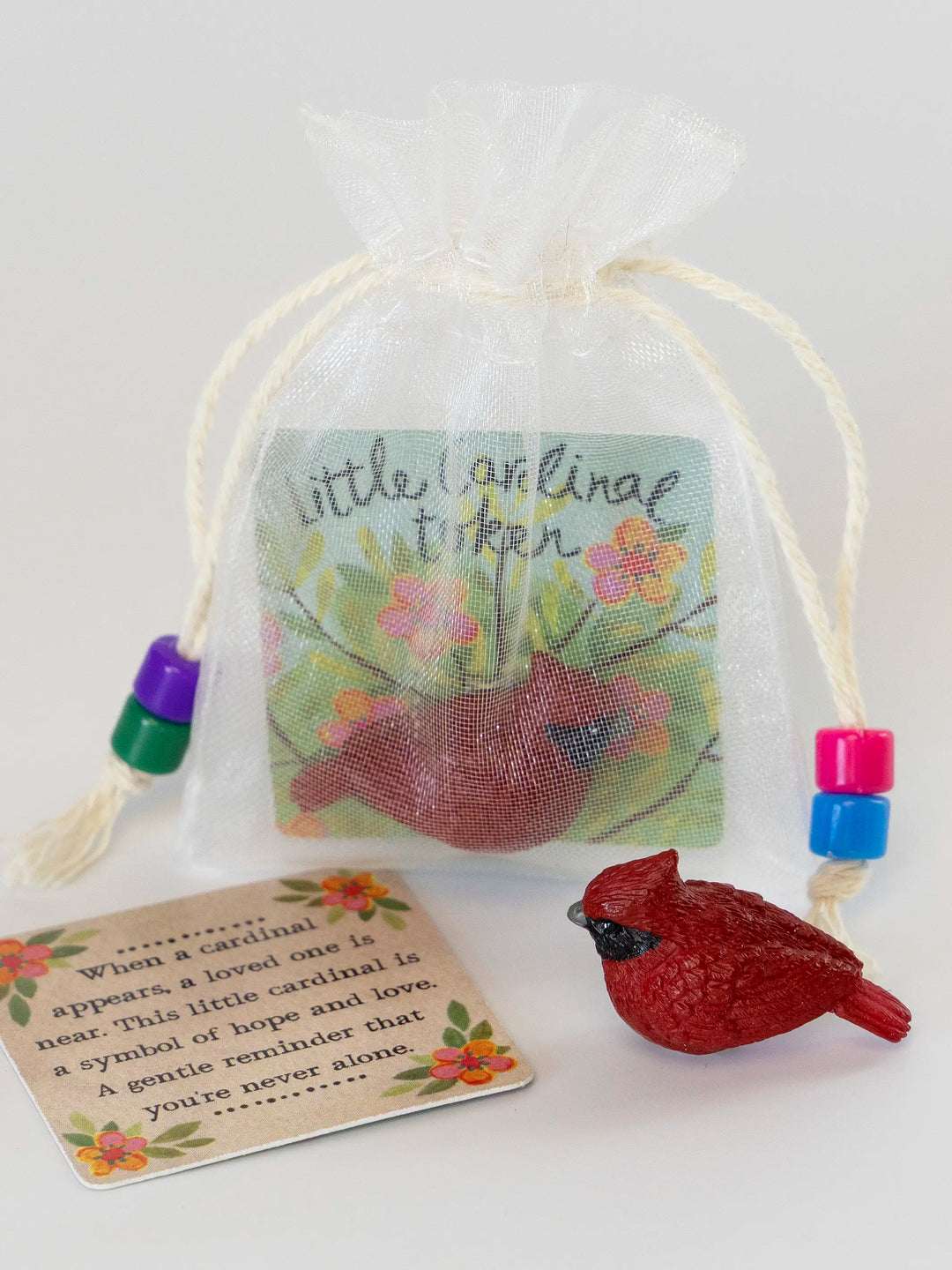 Decorative gift bag with a red cardinal bird and a card on a white background