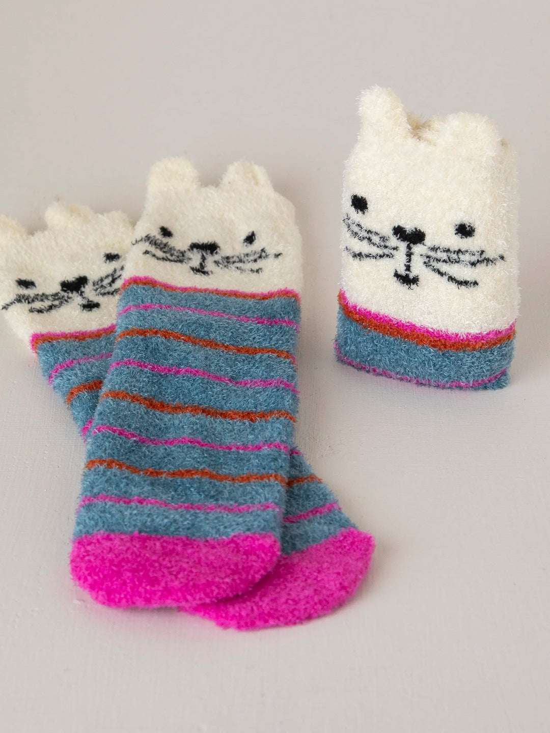 Pair of cat-themed socks with striped pattern on a light gray background