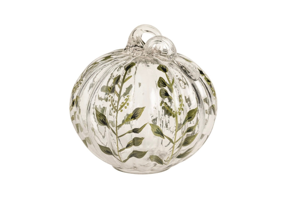 A clear glass pumpkin-shaped ornament decorated with hand-painted green botanical leaf and vine patterns, shown against a plain white background.