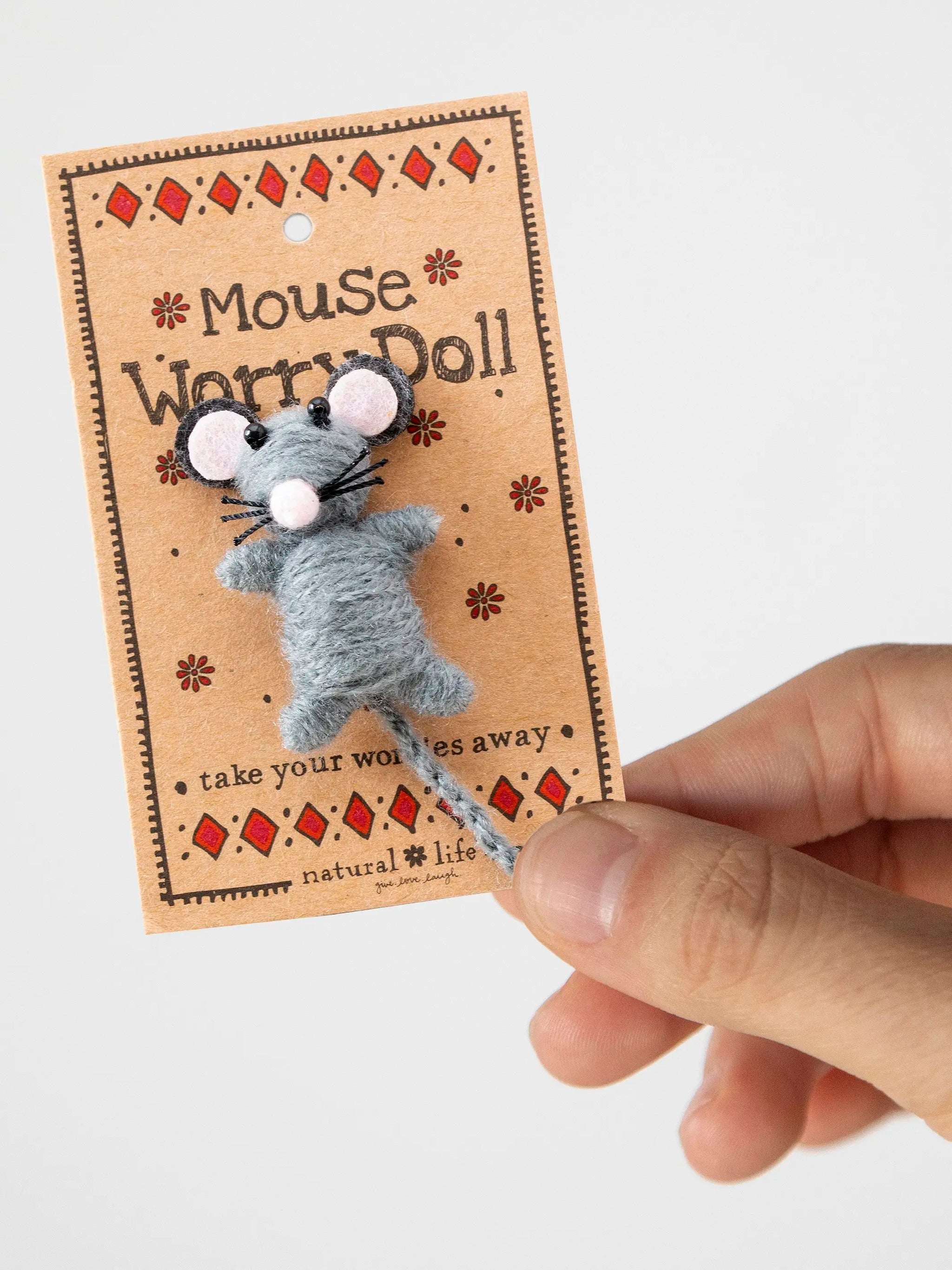Mouse worry doll on a decorative card held by a hand