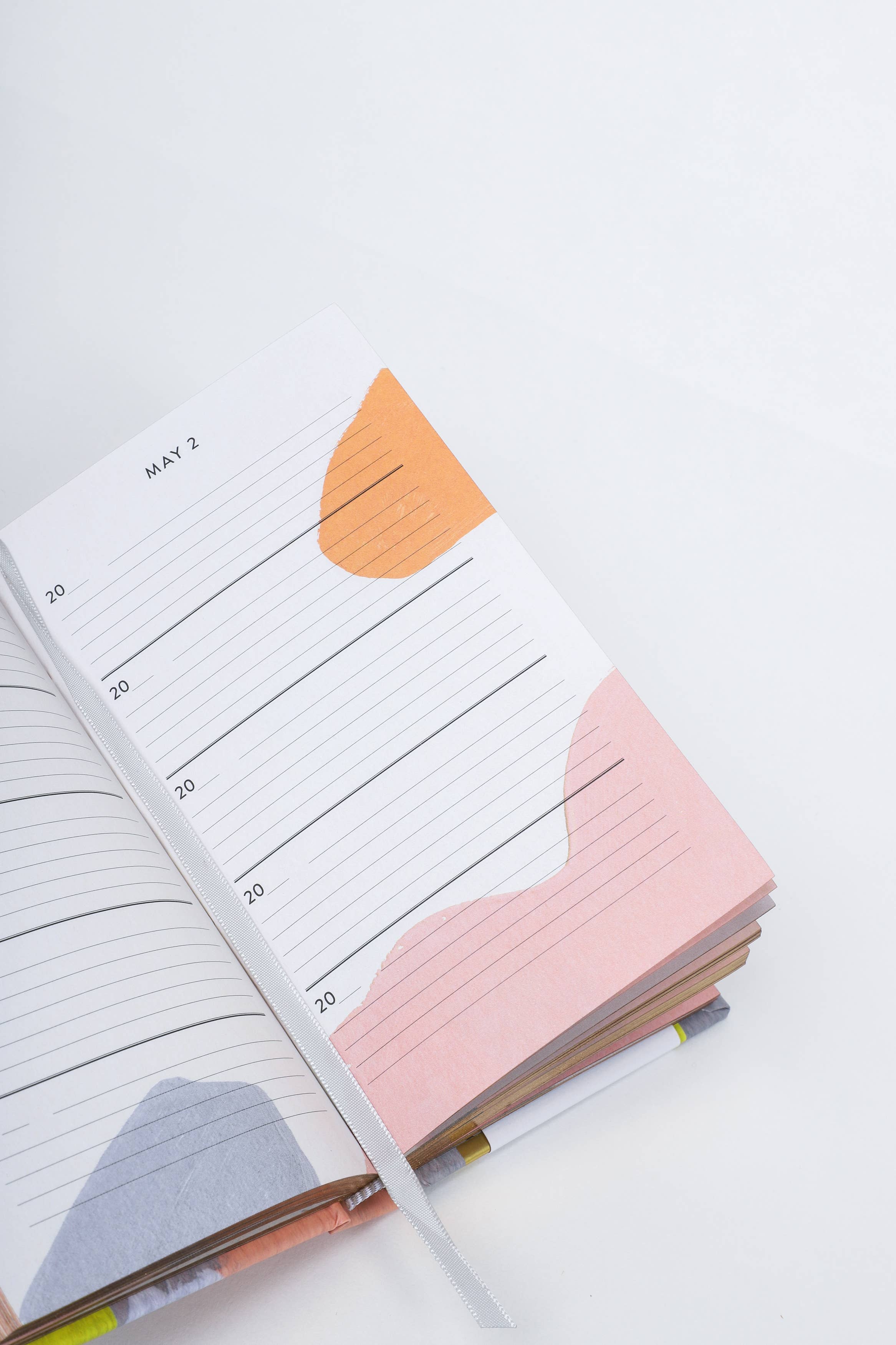 Small planner with colorful tabs on a white background