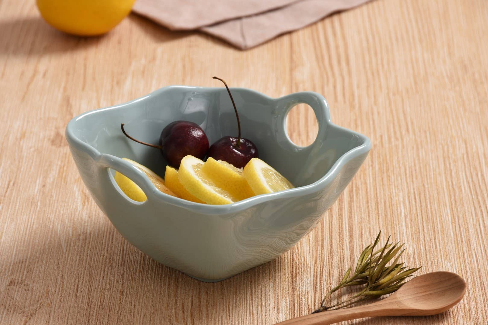 Light blue ceramic bowl with fruit on a wooden surface