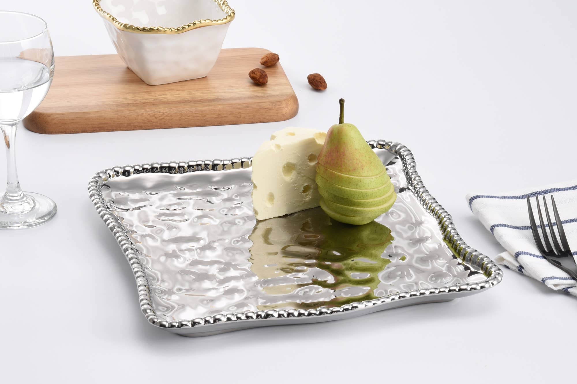 Silver tray with a pear on a white surface
