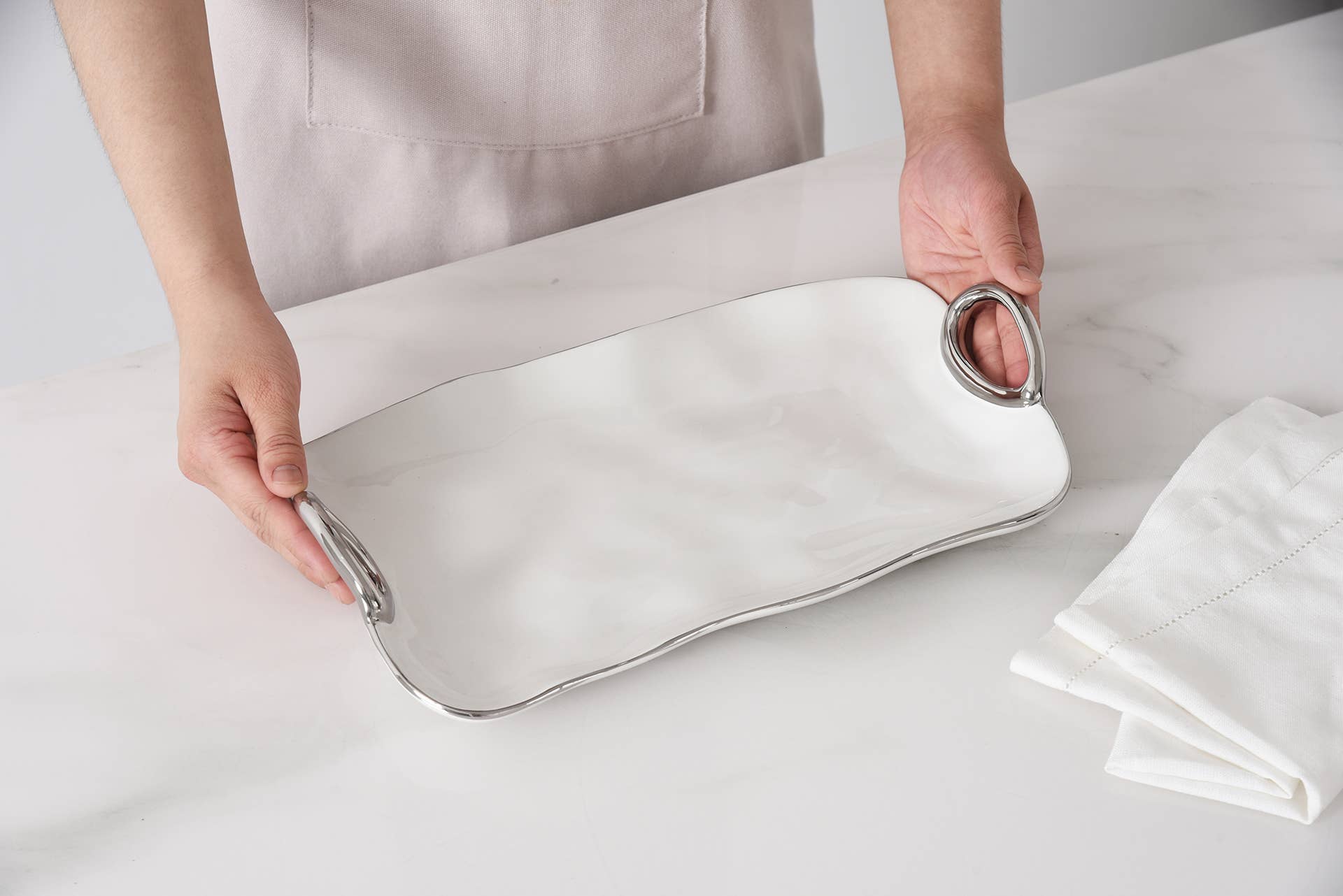 Person holding a white pillow with metal clips on a light background