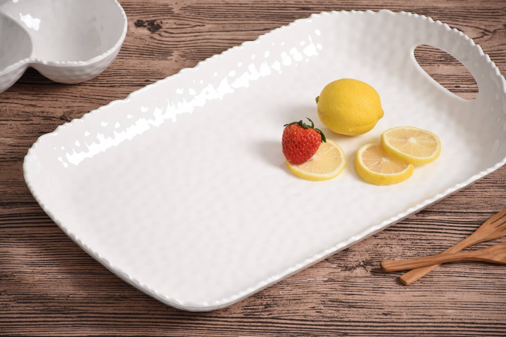 White ceramic tray with fruit on a wooden surface
