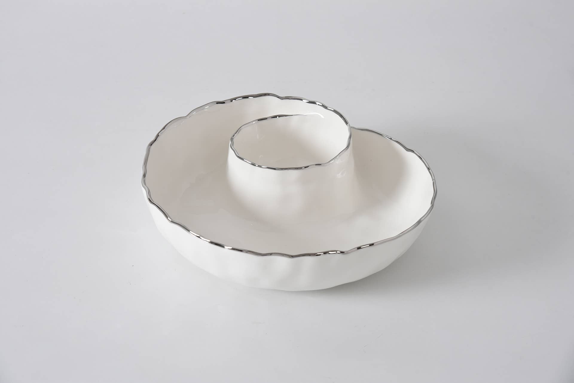 White ceramic bowl with decorative rim on a light gray background