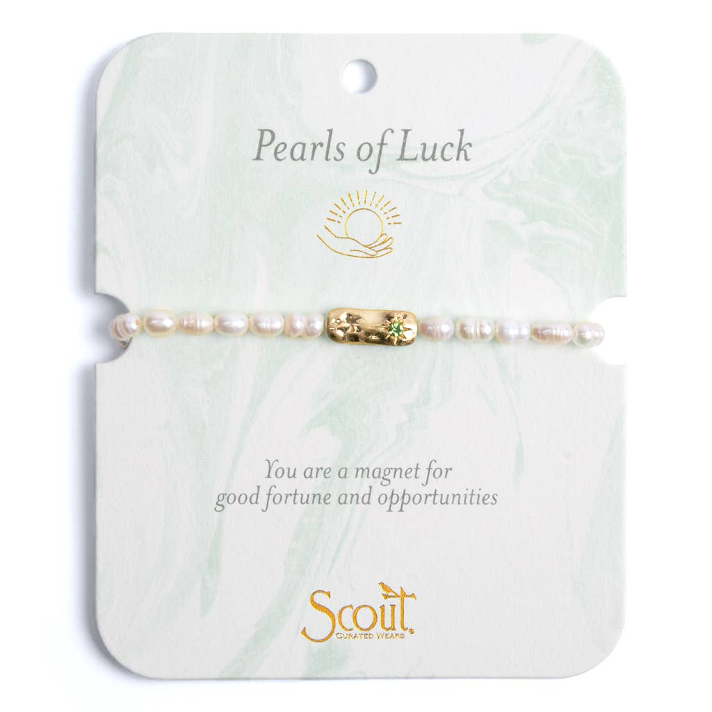 A bracelet featuring a mix of freshwater pearls and gold-plated brass medallions, displayed on a card with 'Pearls of Luck' text and a sun design.