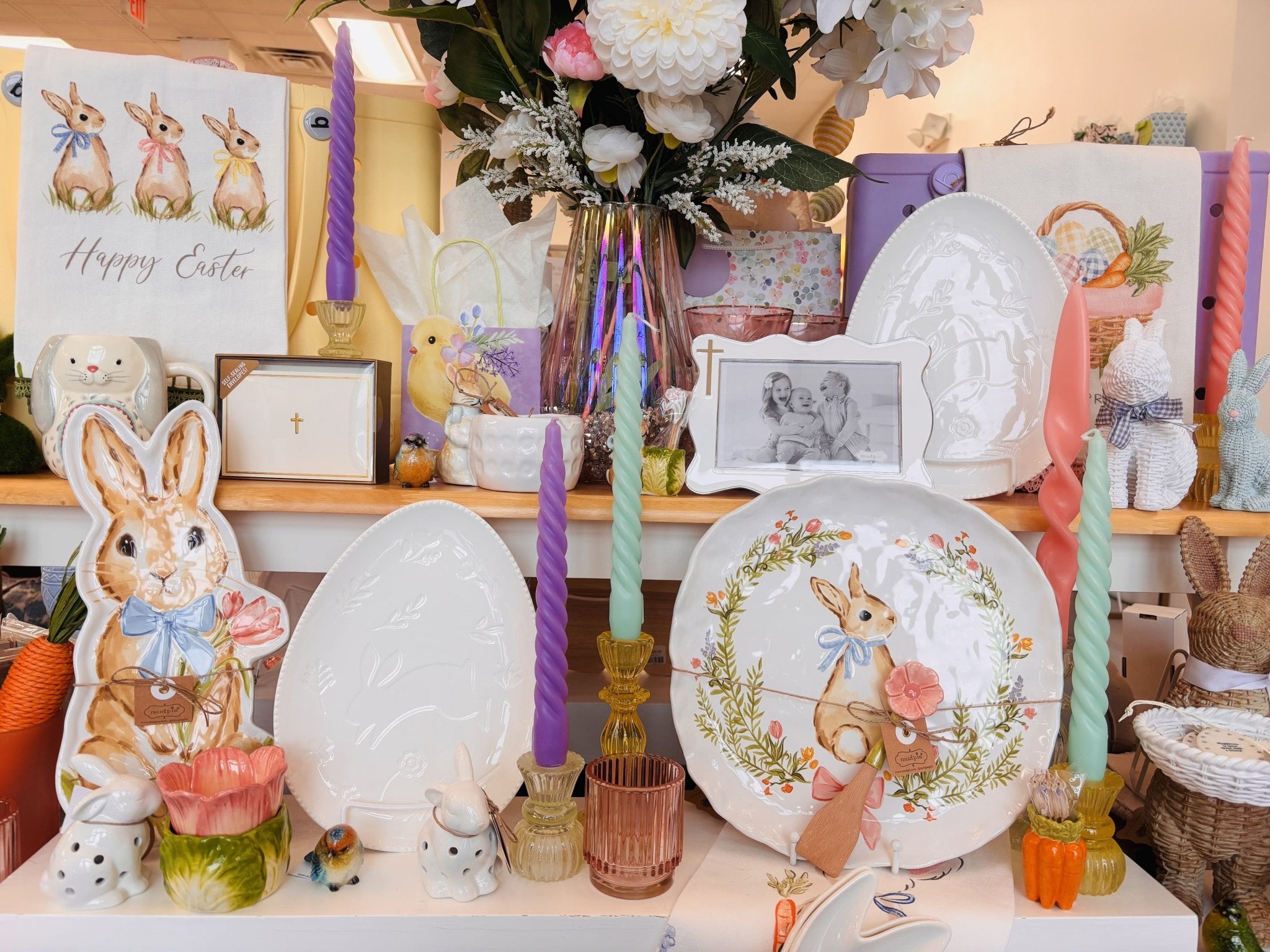 Display of Easter-themed decor items including plates, candles, and figurines.