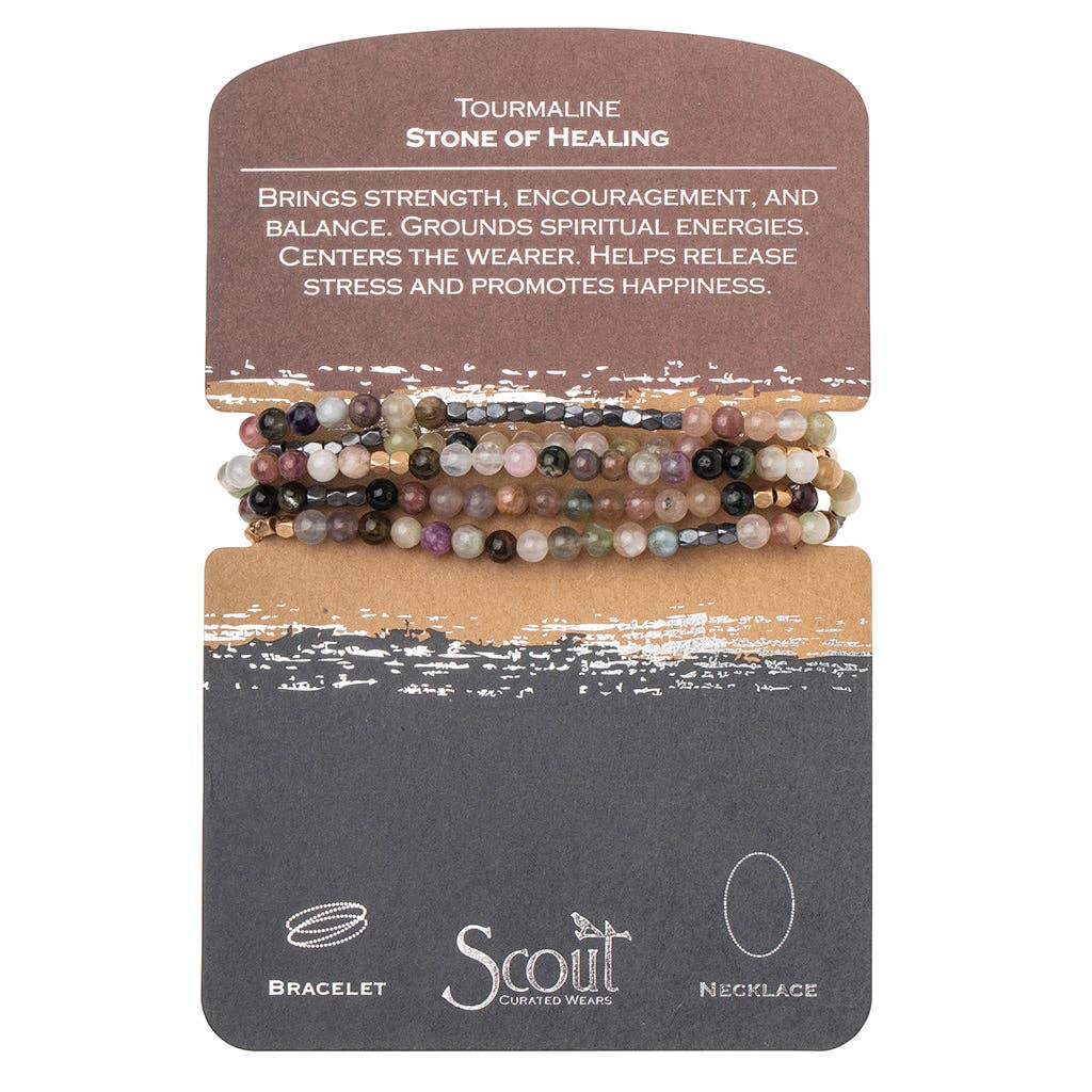 A bracelet made with tourmaline beads and plated brass, displayed on a card with the text 'Tourmaline - Stone of Healing', and the brand 'Scout' and 'Bracelet' visible.