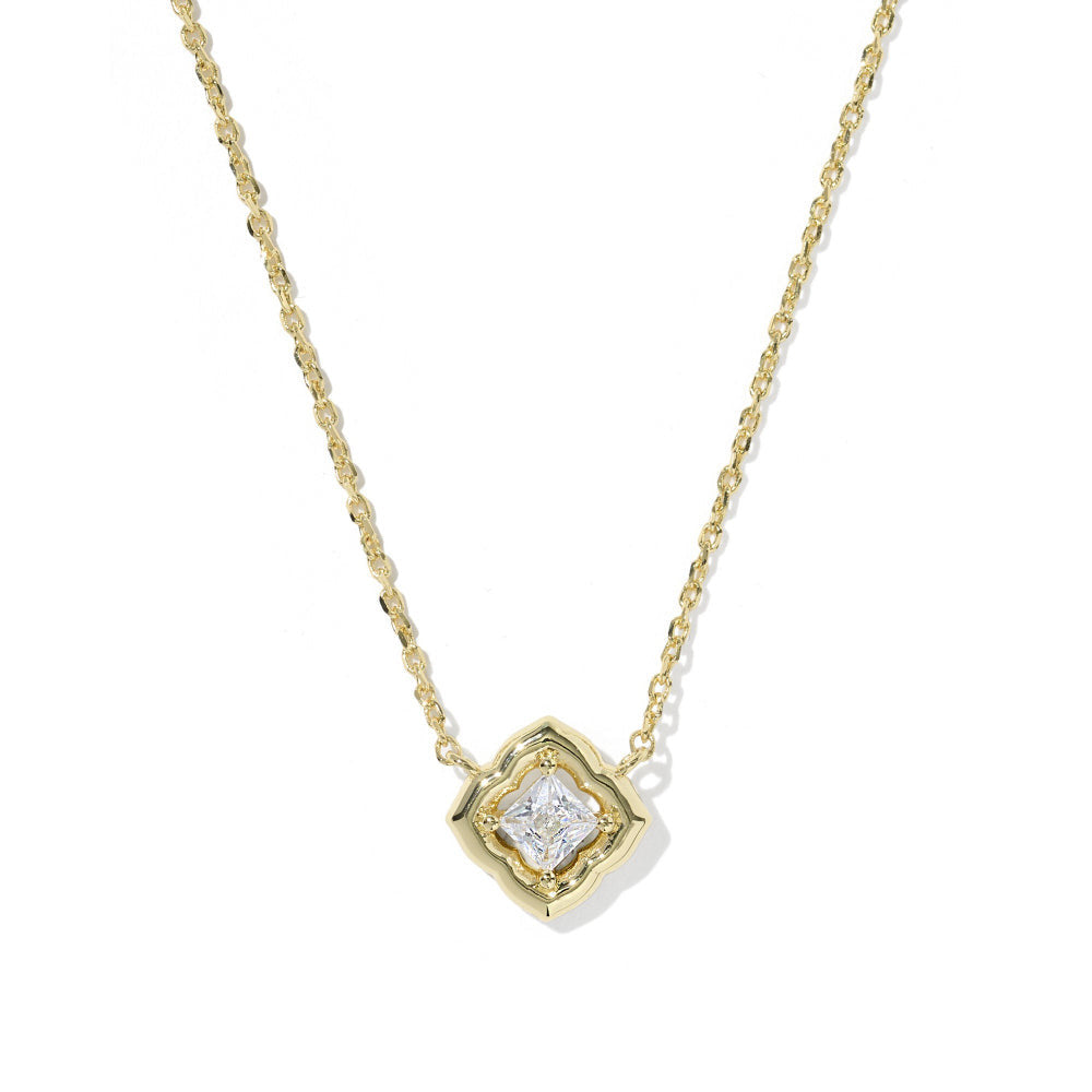 A delicate yellow gold chain necklace with a small geometric pendant featuring a clear central gemstone, shown against a plain white background.