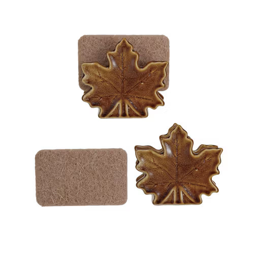 Two brown leaf-shaped coasters on a white background