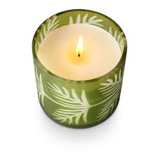 Green candle holder with a lit candle on a white background