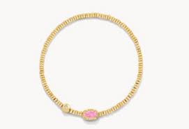 Gold bracelet with a pink gemstone on a white background