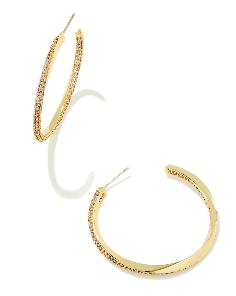 A pair of gold hoop earrings with white crystal embellishments and gold over brass material.
