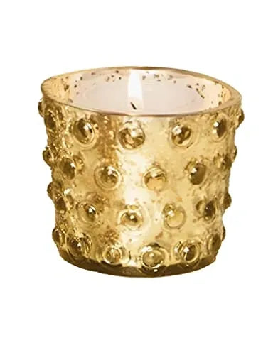 Gold textured candle holder with a lit candle on a white background