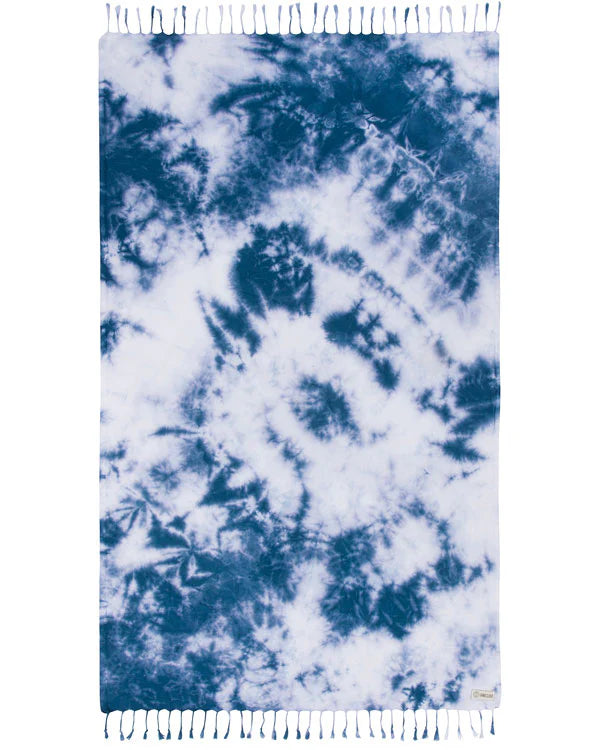 A navy acid wash beach towel with tie-dye patterns and fringed edges.