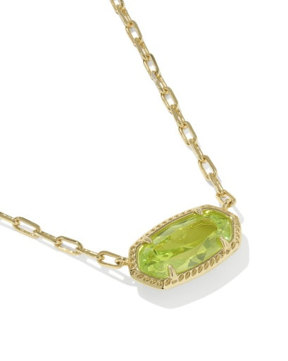 Gold necklace with a green gemstone pendant on a white background
