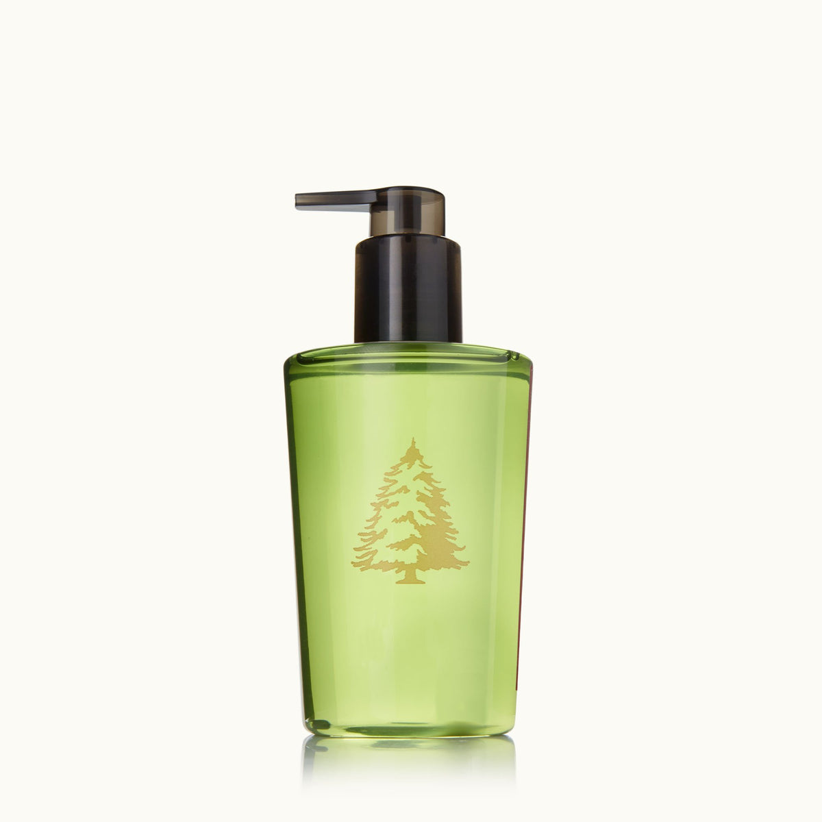 A pump bottle of Thymes hand wash with a green label featuring an illustration of a Frasier Fir tree.