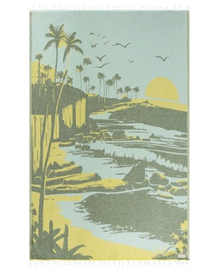 Towel with a tropical landscape design featuring palm trees, a house, and a sunset.